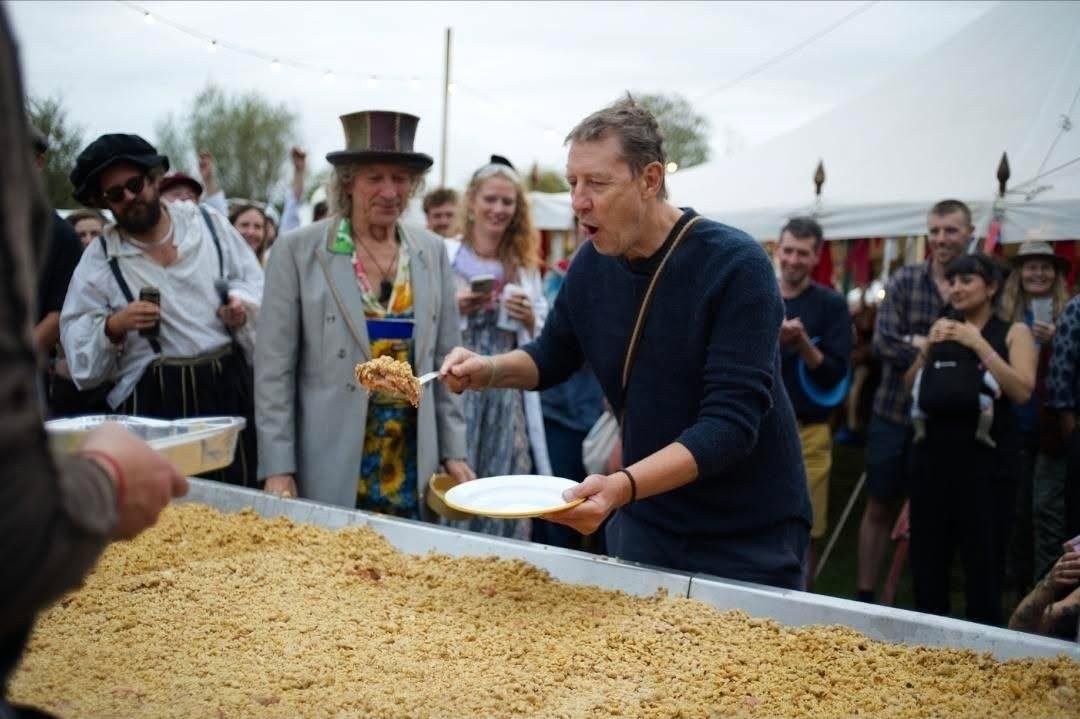 The world's biggest apple crumble cooking over an open fire in giant metal trays